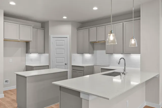 a kitchen with a sink dishwasher and a stove with wooden floor