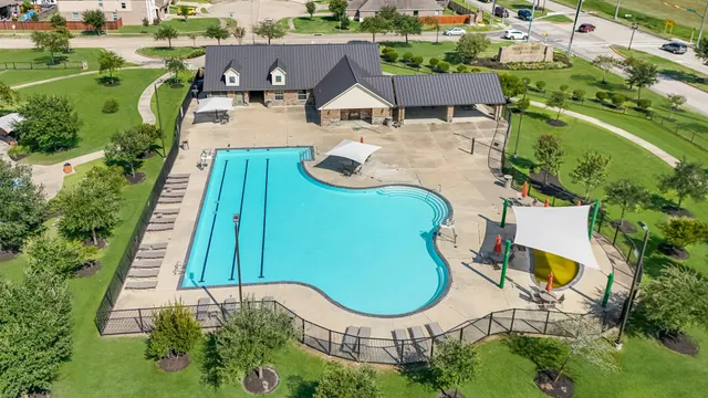 an aerial view of a house with swimming pool and outdoor seating