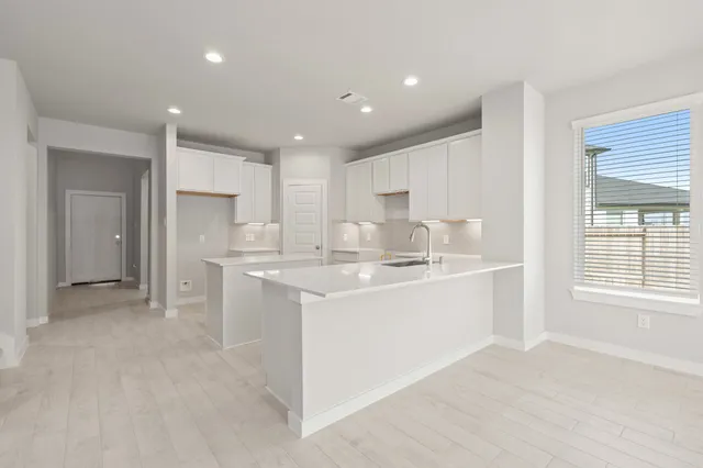 a kitchen with kitchen island sink and refrigerator
