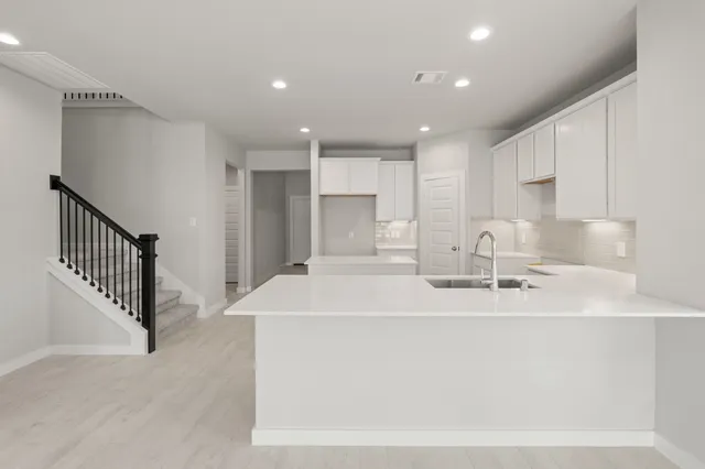 a kitchen with kitchen island sink stainless steel appliances and cabinets
