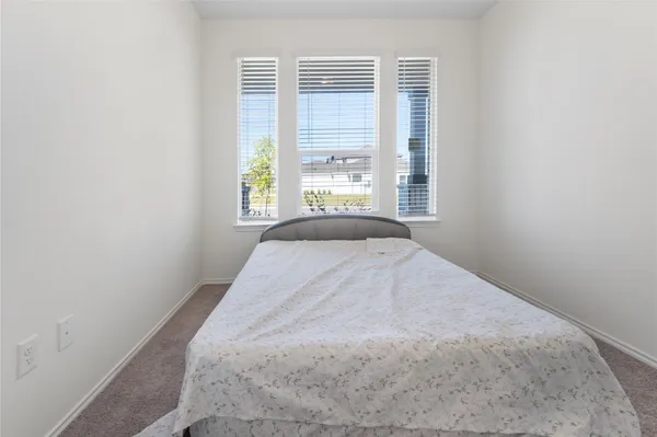 a bed sitting in a bedroom next to a window