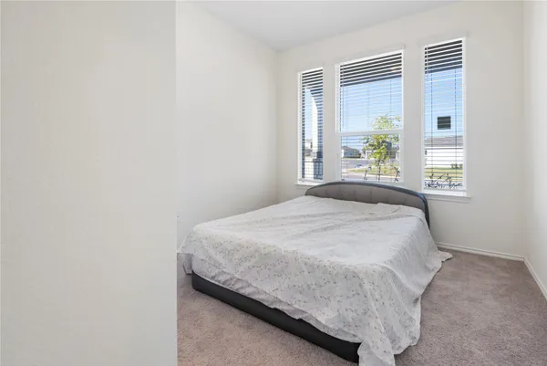 a bed sitting in a bedroom next to a window