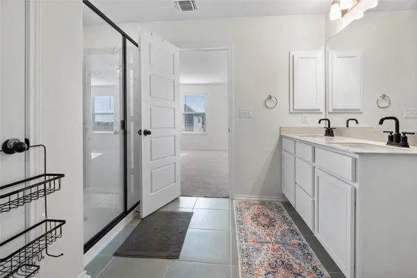 a bathroom with a sink and mirror with shower