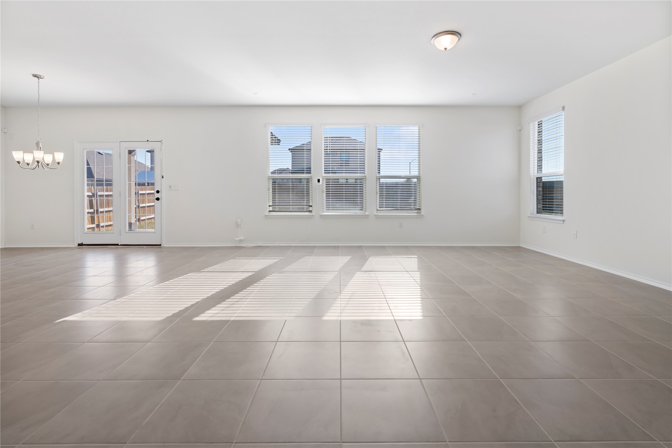 18501 Spotted Eagle Lane Elgin, TX 78621 - Photo 34 of 40 Tiled spare room with a chandelier and baseboards