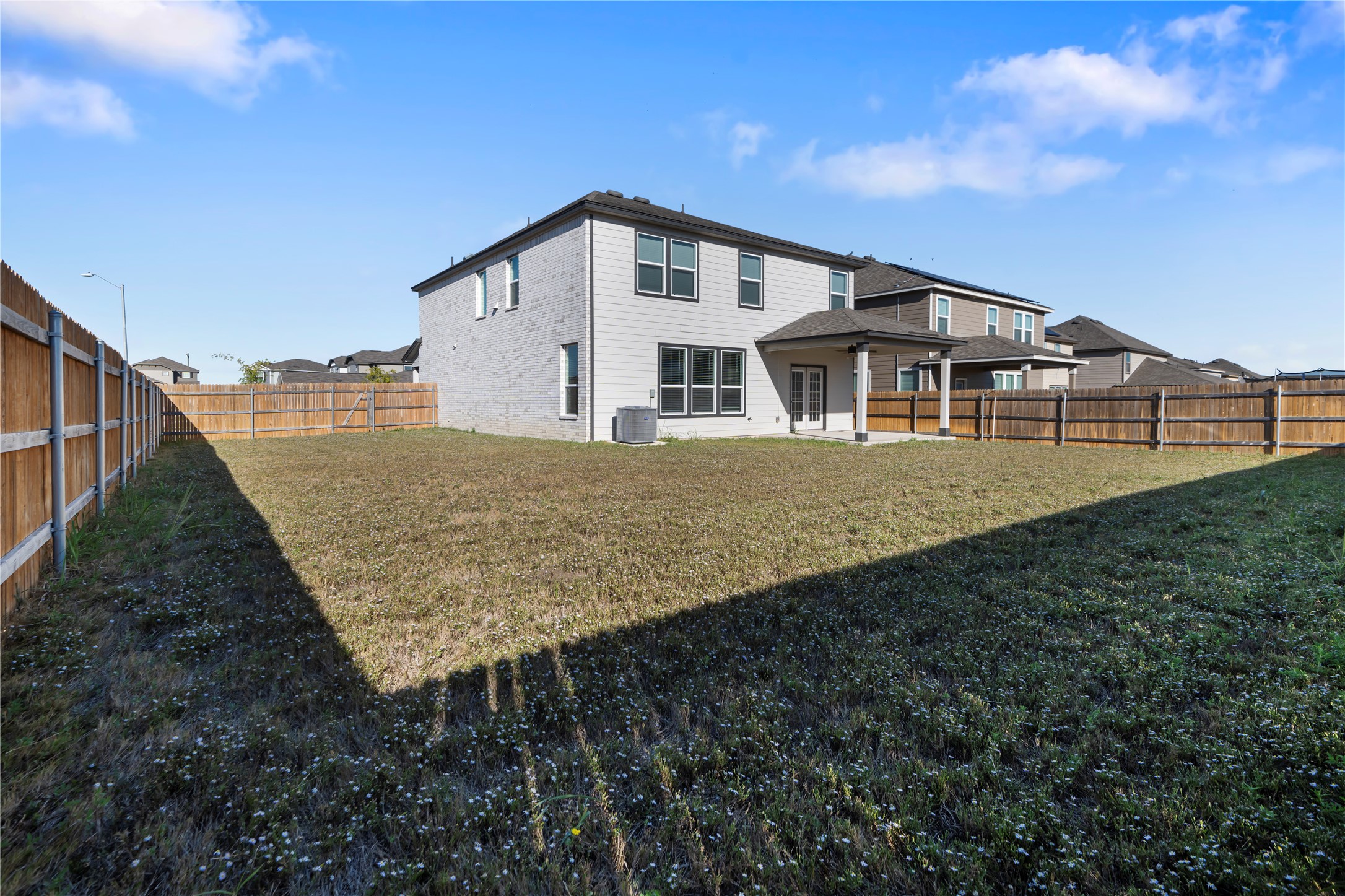 18501 Spotted Eagle Lane Elgin, TX 78621 - Photo 39 of 40 Rear view of house with a patio and a fenced backyard