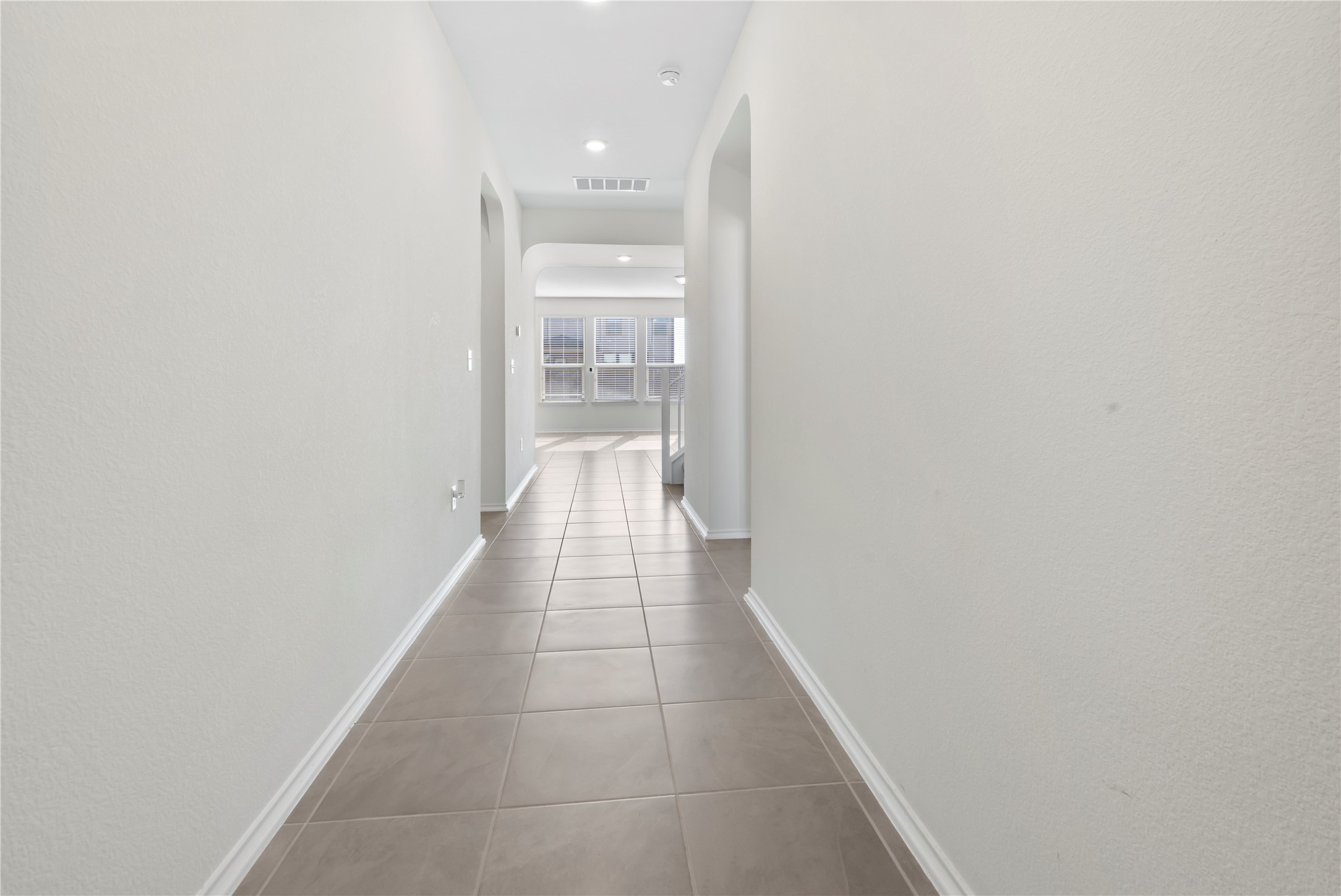18501 Spotted Eagle Lane Elgin, TX 78621 - Photo 4 of 40 Hall featuring arched walkways, tile patterned flooring, and recessed lighting