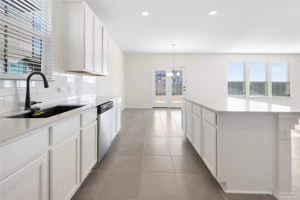 a kitchen with stainless steel appliances granite countertop white cabinets and window