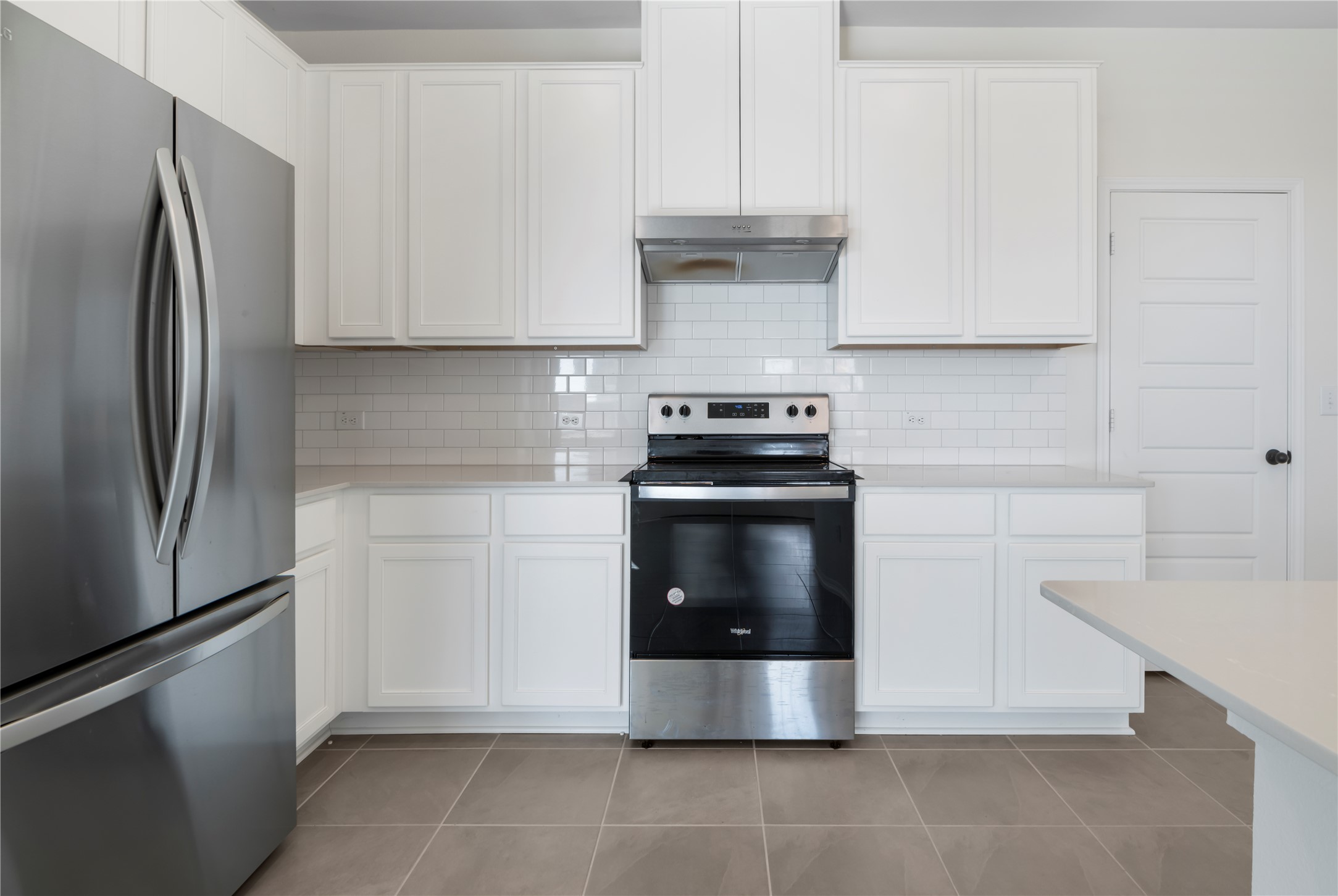 18501 Spotted Eagle Lane Elgin, TX 78621 - Photo 6 of 40 Kitchen with stainless steel appliances, white cabinets, and exhaust hood