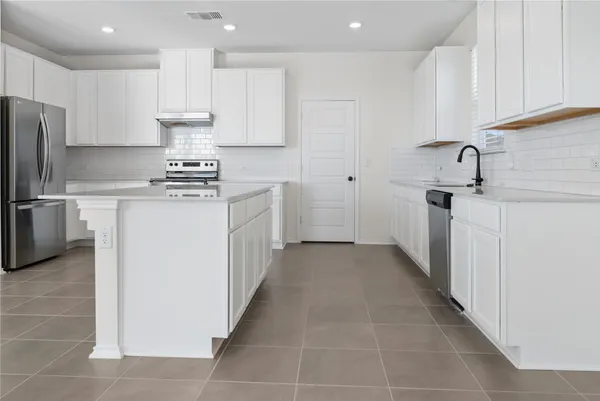 a kitchen with stainless steel appliances a refrigerator and a stove