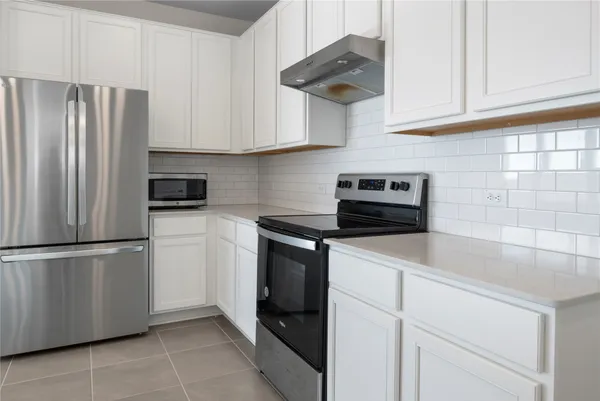 a kitchen with appliances and cabinets
