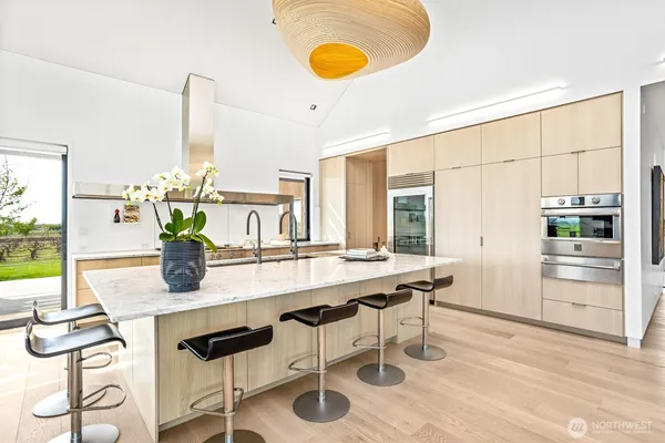 a kitchen with stainless steel appliances granite countertop a stove and a view of living room