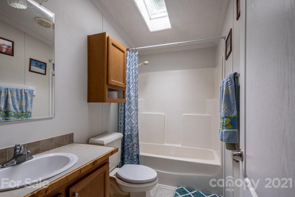 47 Integrity Mountain Otto, NC 28763 - Photo 9 of 22 a bathroom with a granite countertop sink toilet and shower