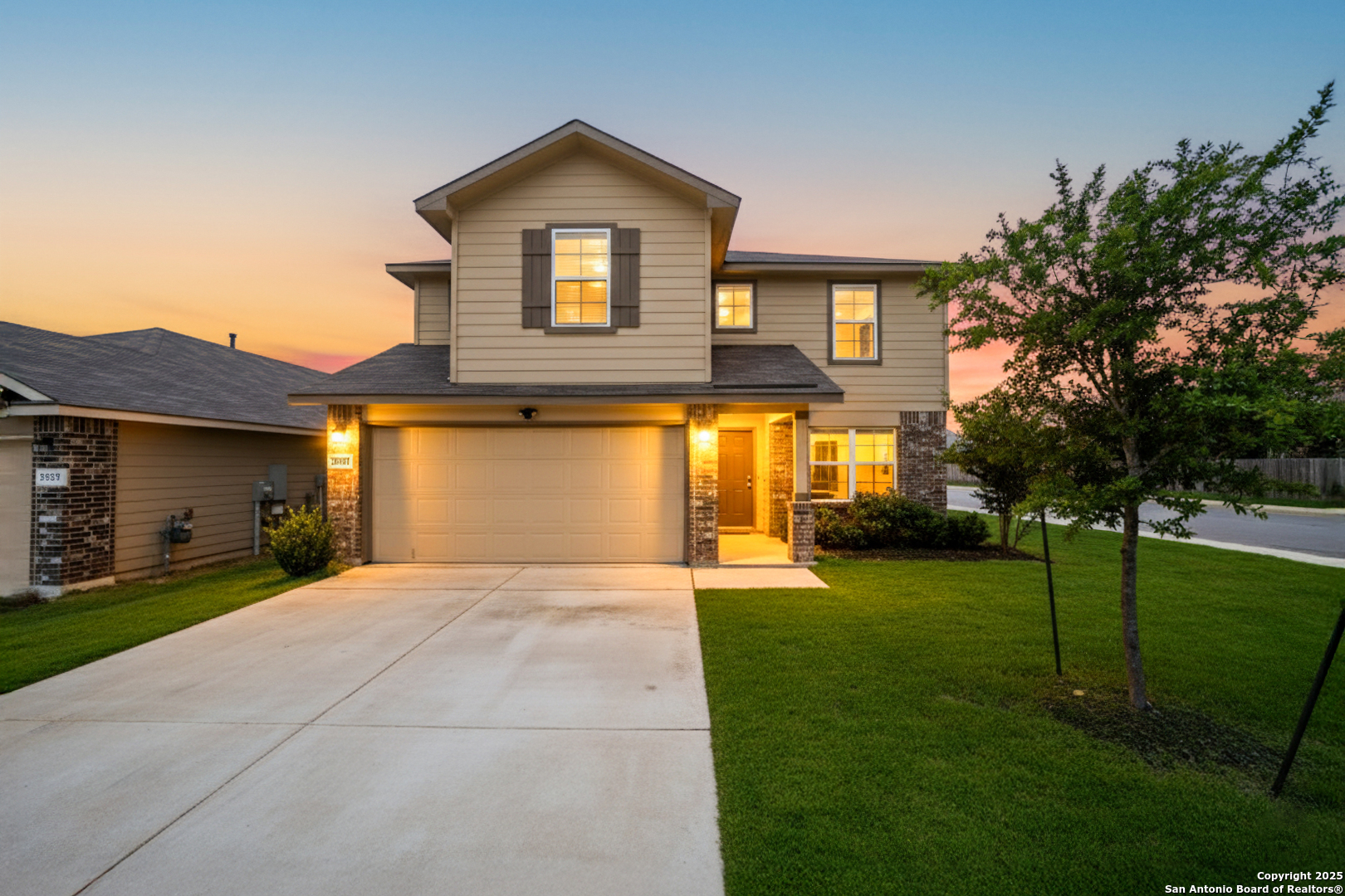 a front view of a house with a yard and trees