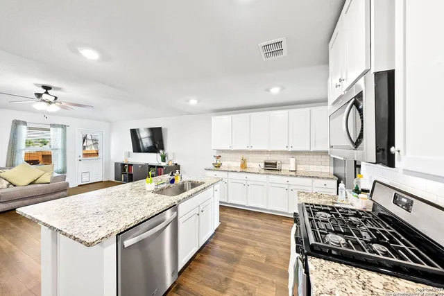 a kitchen with a stove a sink and a refrigerator