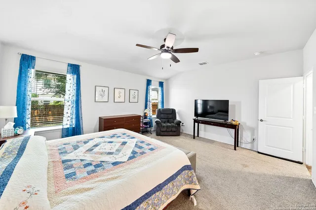 a bedroom with a bed a large window and flat screen tv
