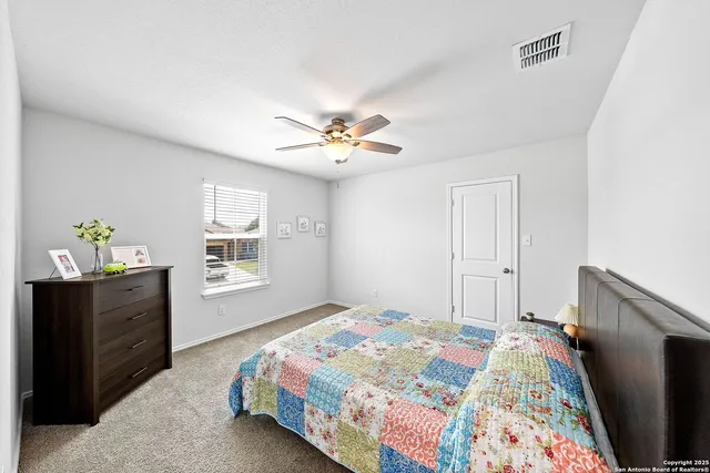 a bedroom with a bed and a chandelier fan