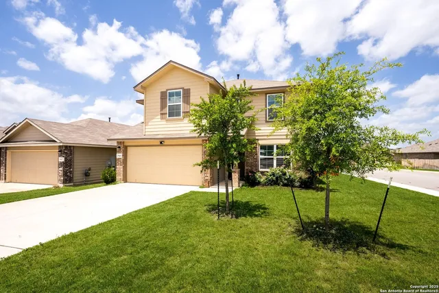 a front view of a house with a yard and trees