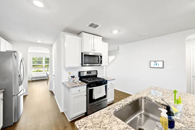 a kitchen with stainless steel appliances kitchen island granite countertop a refrigerator sink and stove