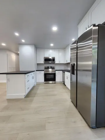 a kitchen with stainless steel appliances granite countertop a refrigerator and a sink