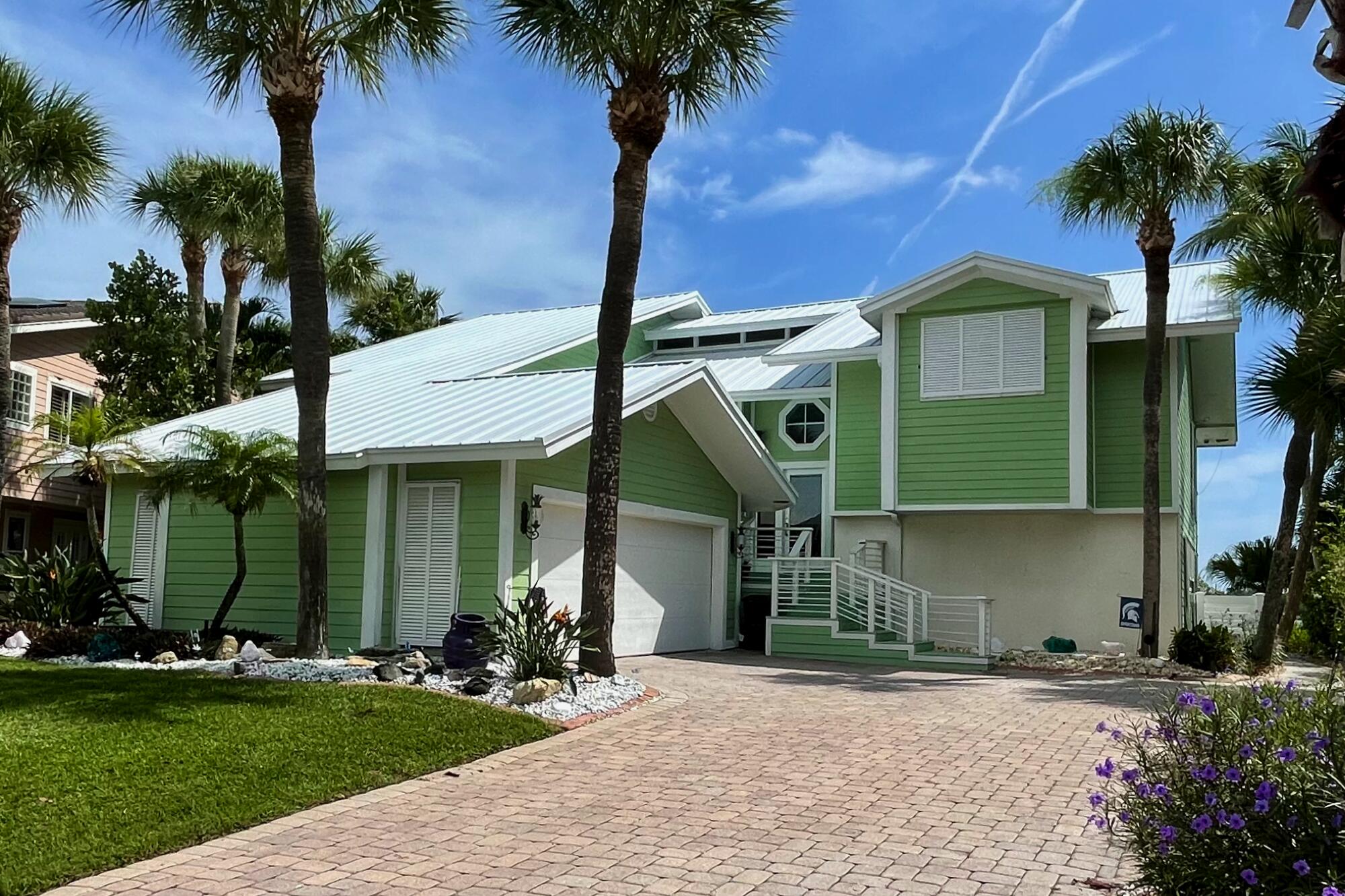 4040 Northeast Joes Point Road Stuart, FL 34996 - Photo 5 of 35 a front view of a house with a garden and trees