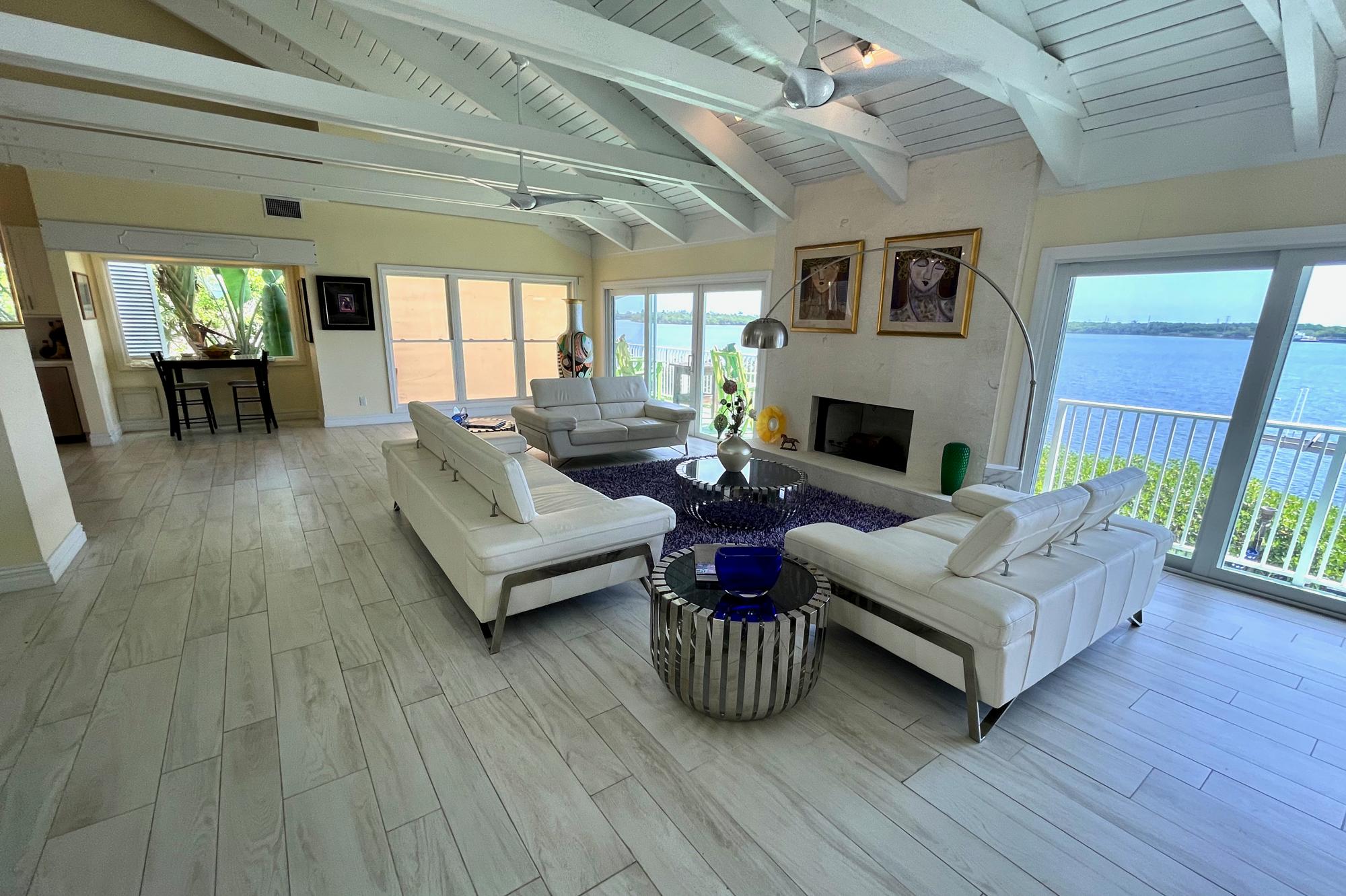 4040 Northeast Joes Point Road Stuart, FL 34996 - Photo 8 of 35 a living room with furniture large window and a fireplace