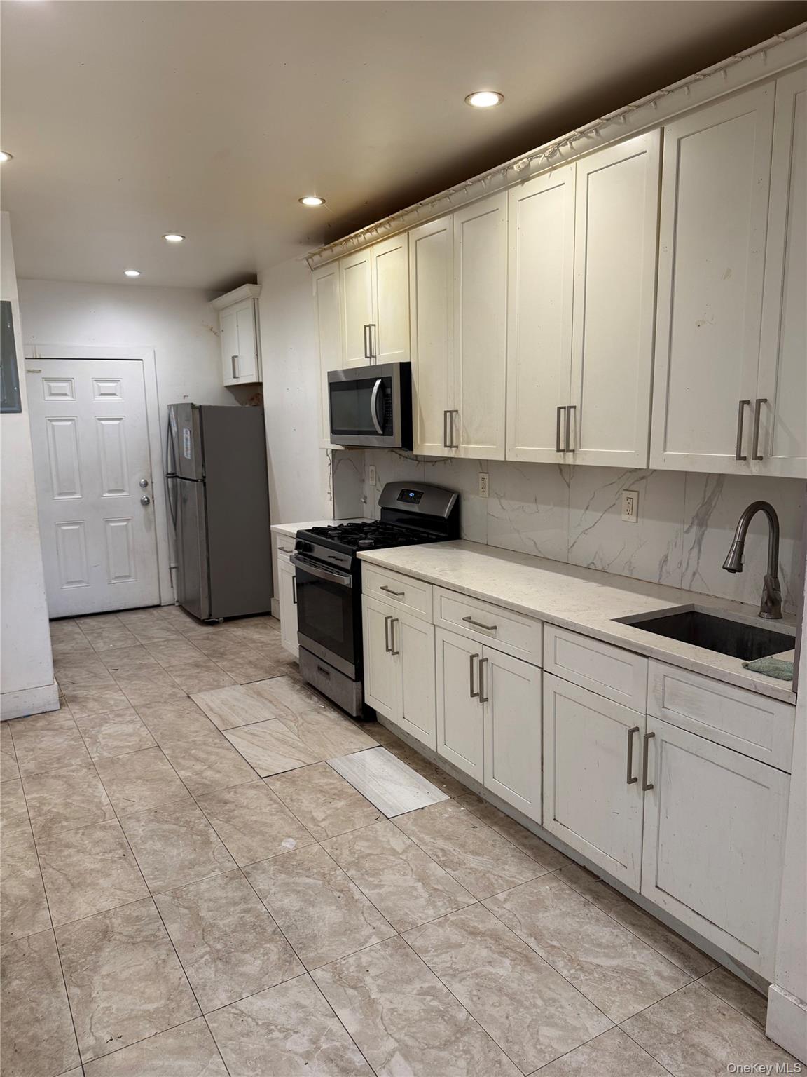 737 Sheffield Avenue, Unit 1R Brooklyn, NY 11207 - Photo 2 of 7 a kitchen with stainless steel appliances a refrigerator sink and cabinets