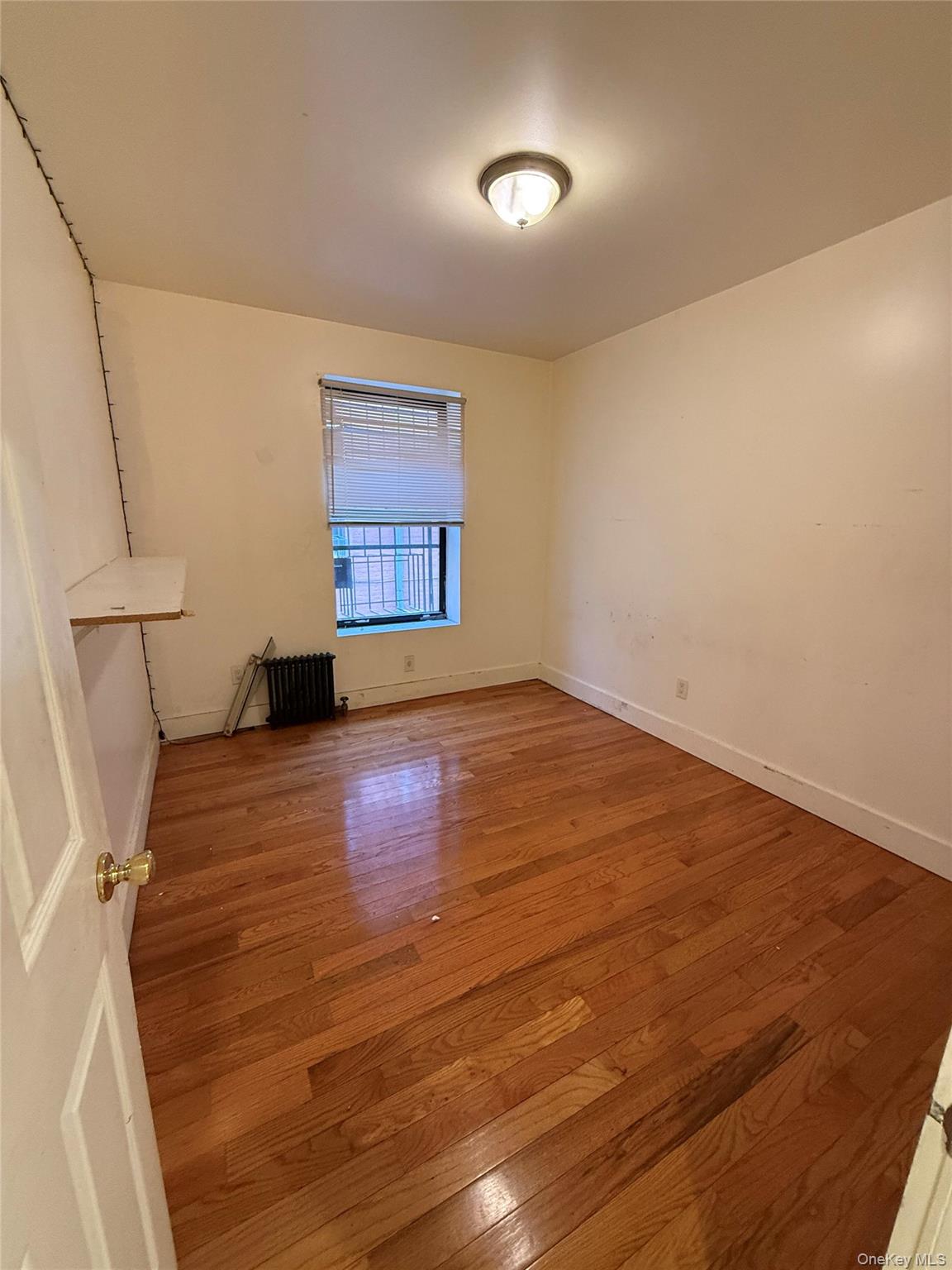 737 Sheffield Avenue, Unit 1R Brooklyn, NY 11207 - Photo 7 of 7 a view of an empty room with wooden floor and a window