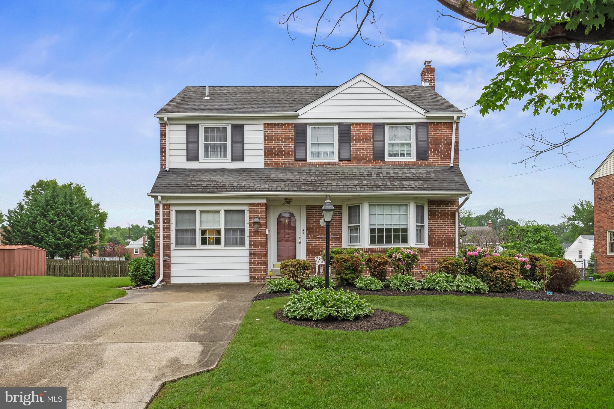 a front view of a house with a garden and plants