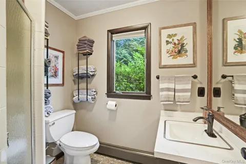 a bathroom with a sink a toilet and a window