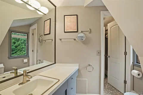a bathroom with a sink and mirror with toilet
