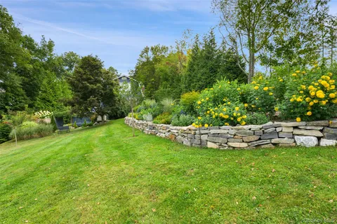a view of a big yard with table and chairs and wooden fence