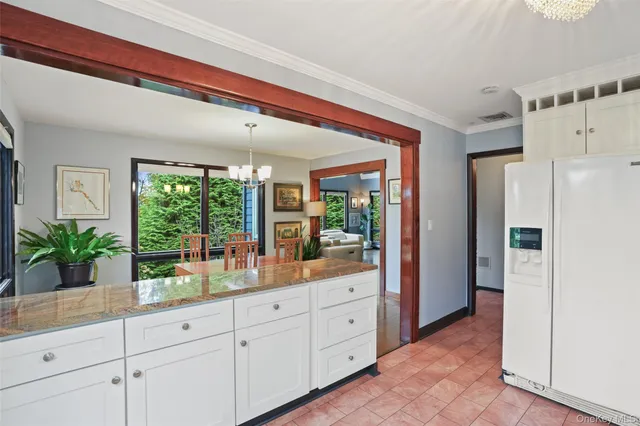 a kitchen with white cabinets and a window