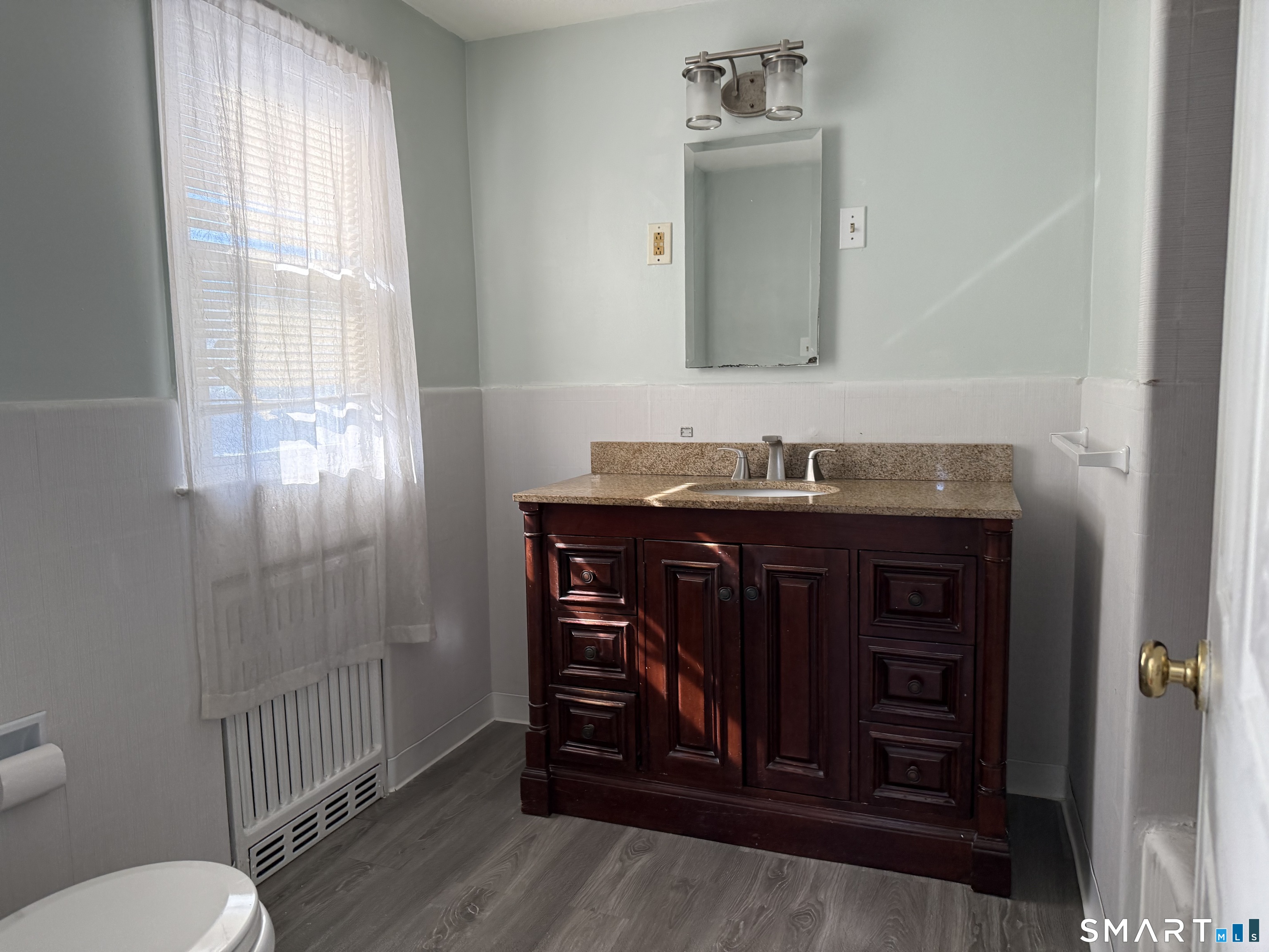 95-97 Locust Street Bridgeport, CT 06610 - Photo 12 of 16 a bathroom with a sink vanity mirror and toilet