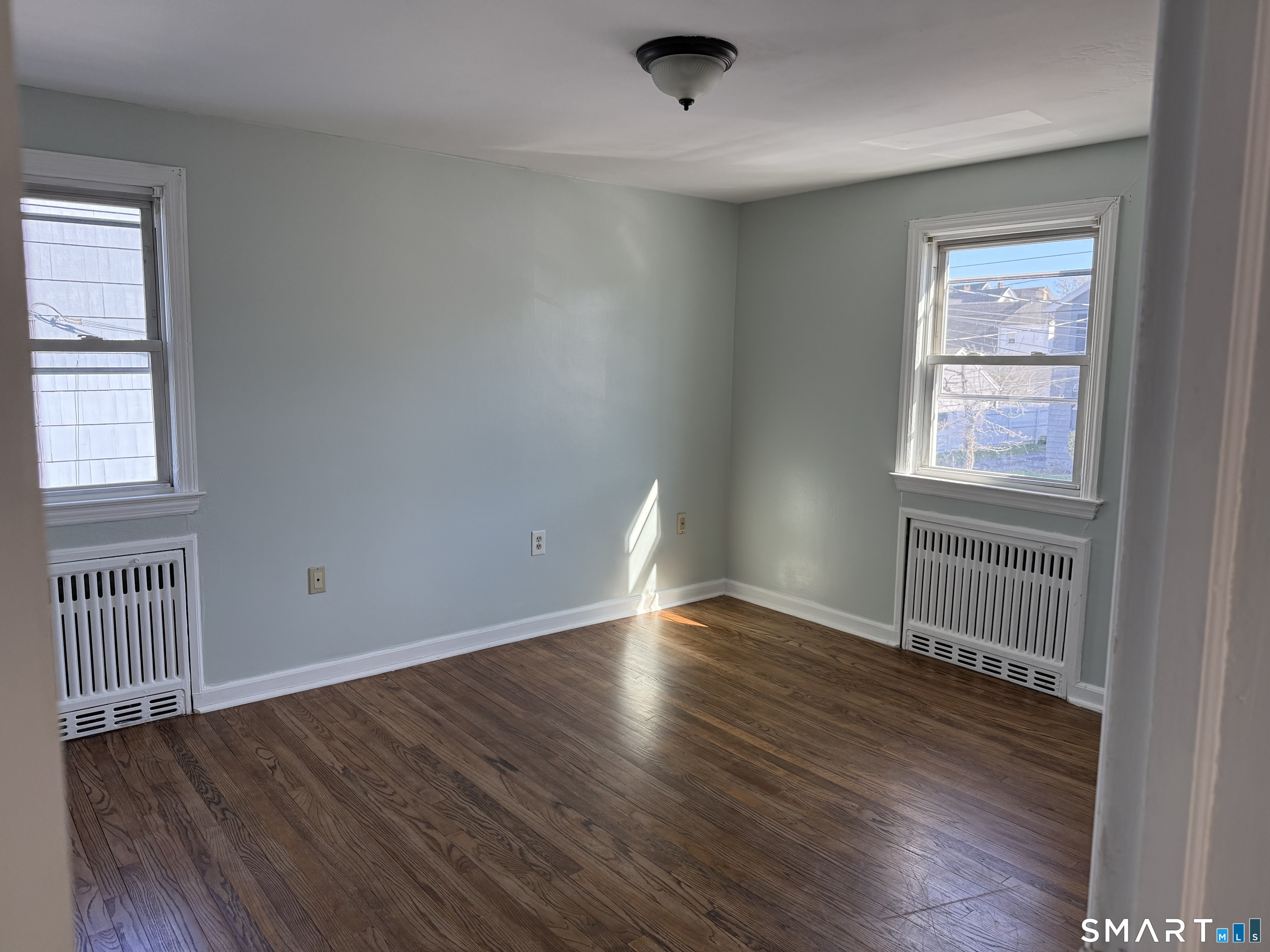 95-97 Locust Street Bridgeport, CT 06610 - Photo 15 of 16 an empty room with wooden floor and windows