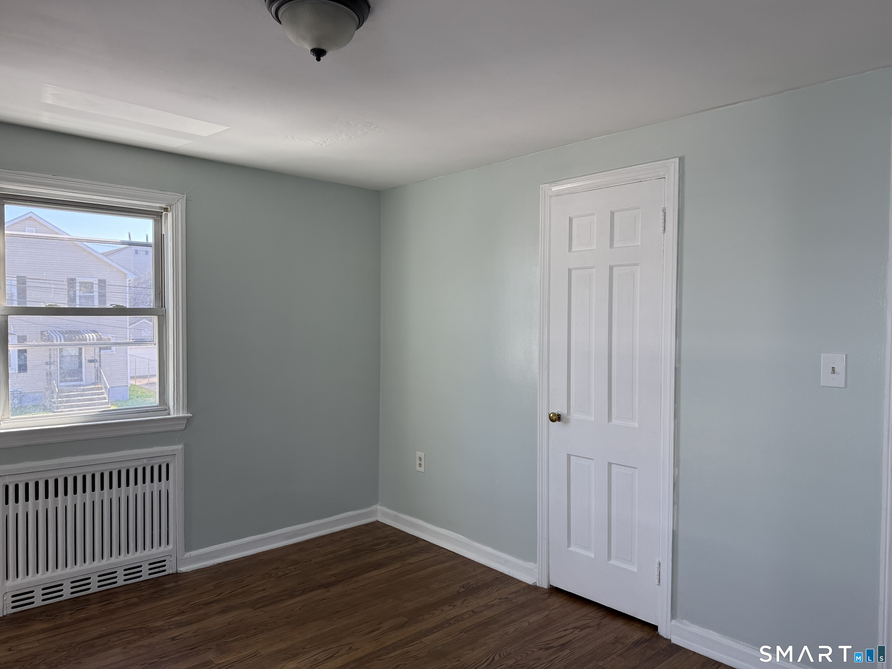 95-97 Locust Street Bridgeport, CT 06610 - Photo 2 of 16 a view of an empty room with wooden floor and a window