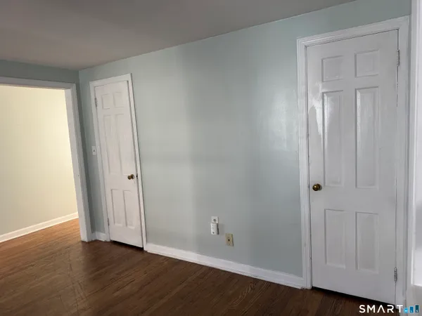 an empty room with wooden floor and closet area