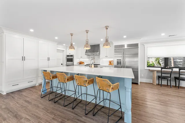 a dining hall with stainless steel appliances a dining table and chairs with wooden floor