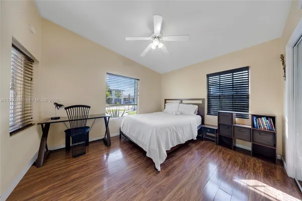 a spacious bedroom with a bed and wooden floor