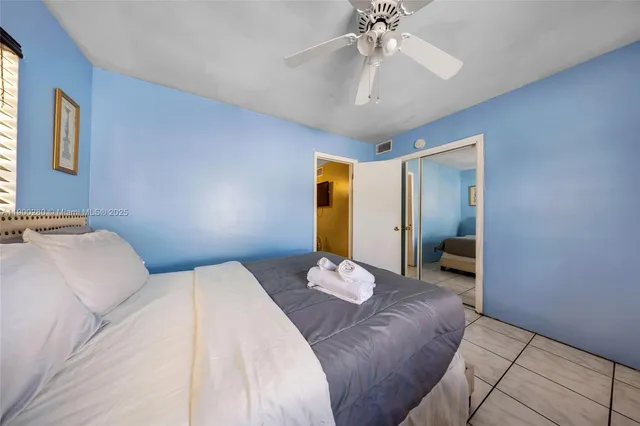 a bedroom with a large bed and ceiling fan