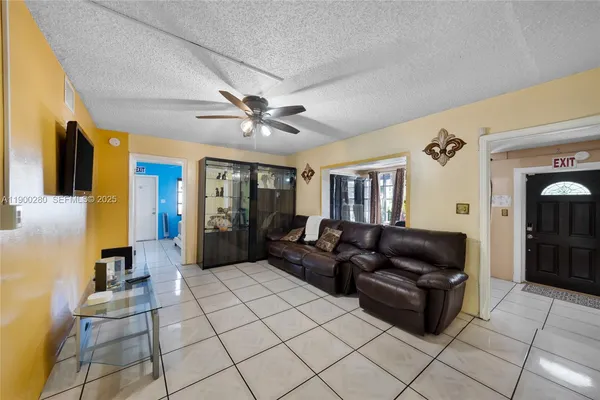 a living room with furniture and a ceiling fan