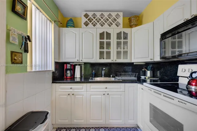 a kitchen with granite countertop a sink and a stove