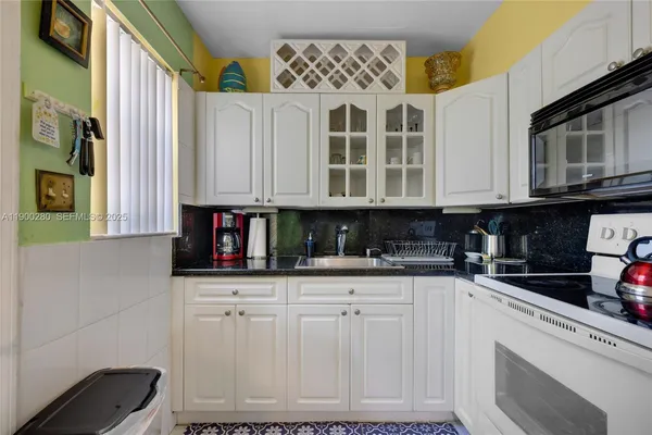 a kitchen with granite countertop a sink and a stove