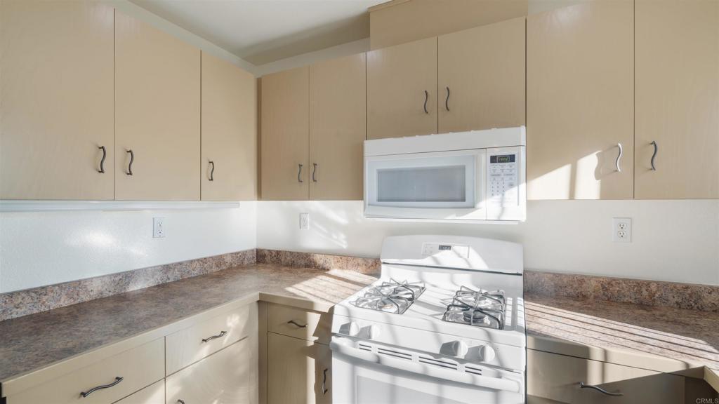 1428 Realty Road Ramona, CA 92065 - Photo 12 of 45 a kitchen with granite countertop white cabinets and white appliances