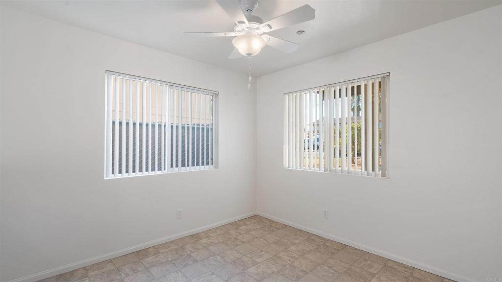 1428 Realty Road Ramona, CA 92065 - Photo 14 of 45 an empty room with chandelier fan and windows