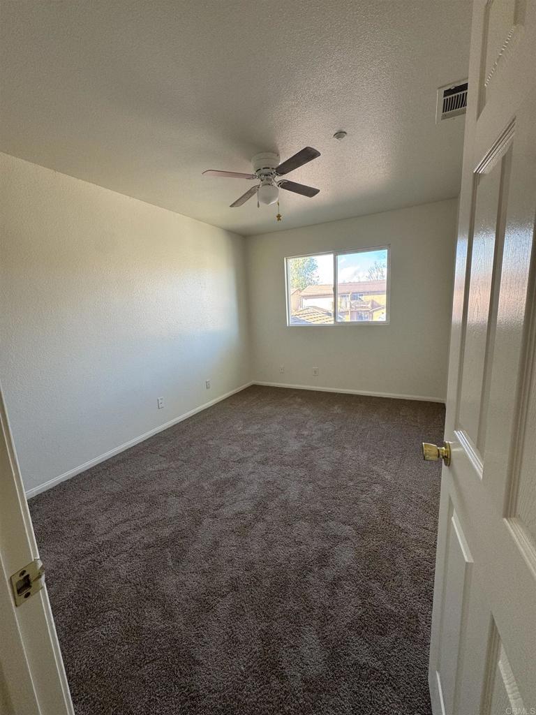 1428 Realty Road Ramona, CA 92065 - Photo 24 of 45 en empty room with windows and a ceiling fan