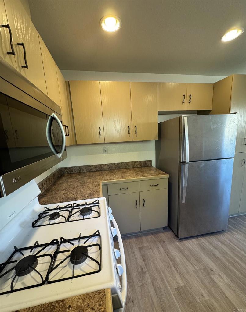 1428 Realty Road Ramona, CA 92065 - Photo 28 of 45 a kitchen with a stove a refrigerator and cabinets