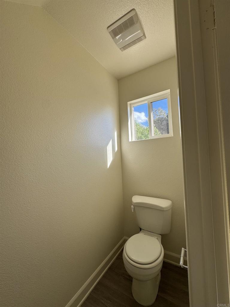 1428 Realty Road Ramona, CA 92065 - Photo 39 of 45 a white toilet sitting next to a white wall