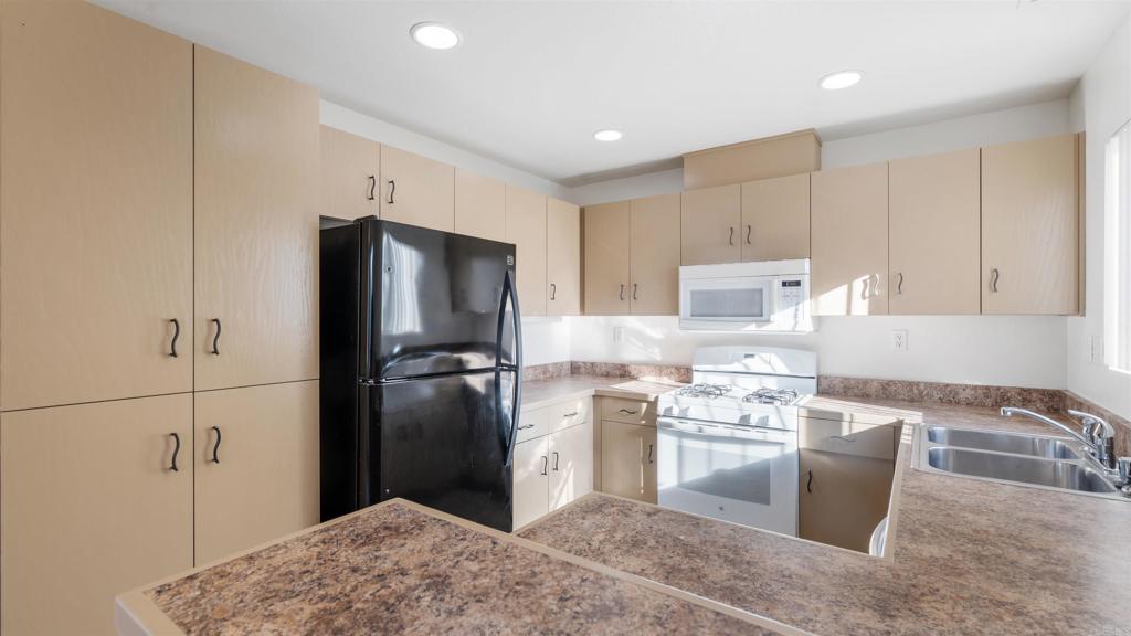 1428 Realty Road Ramona, CA 92065 - Photo 6 of 18 a kitchen with kitchen island a refrigerator sink and stove