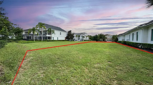 a view of a house next to a big yard with large trees