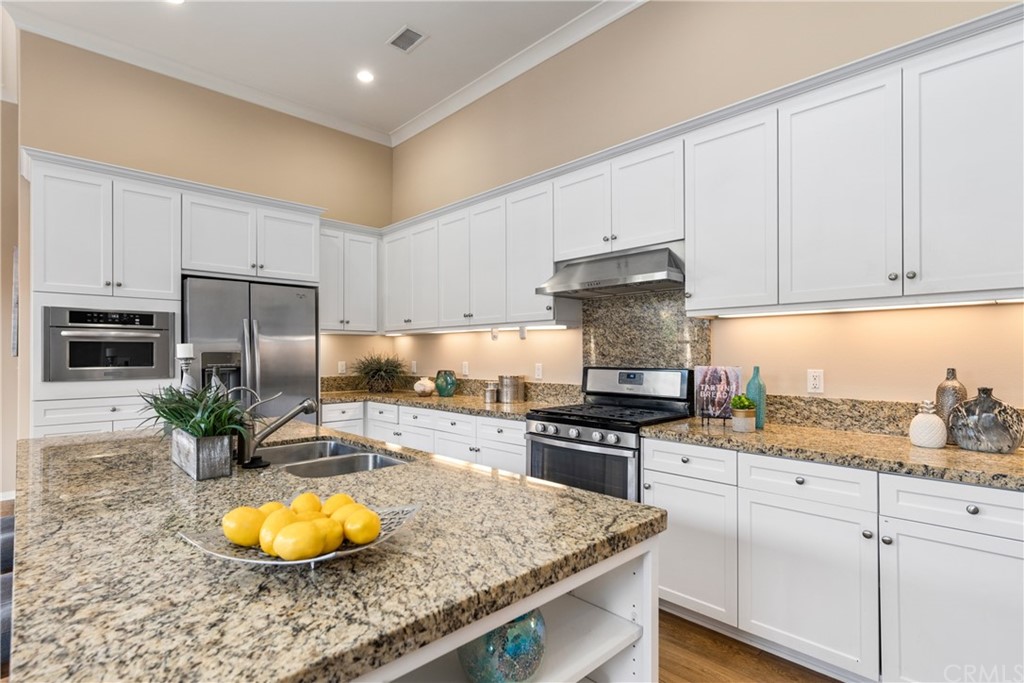 97 Mayfair Irvine, CA 92620 - Photo 12 of 42 a kitchen with stainless steel appliances granite countertop a stove a sink and a microwave